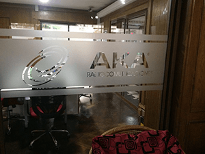 Vinilo empavonado con logo AKA troquelado y franjas decorativas para vidrios.

