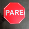 Disco Pare de 30 cm para barreras sostenido con la mano para referencia de dimensión y escala real.